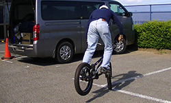 大瀧さんが曲芸用の自転車に乗っています。